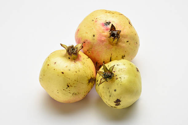 Fresh organic pomegranate fruits on the white background. Group of whole pomegranates