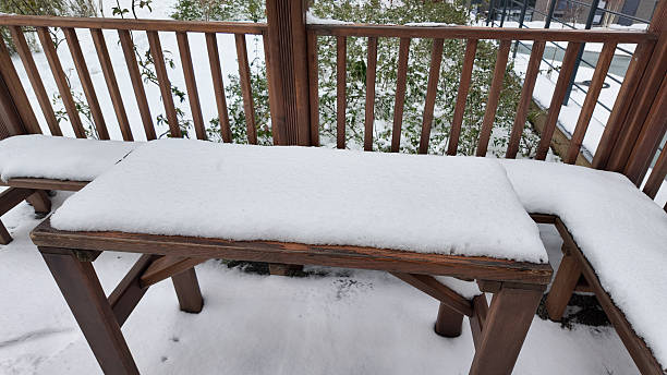 istock Snow covers the wooden table on a winter day 2250005160