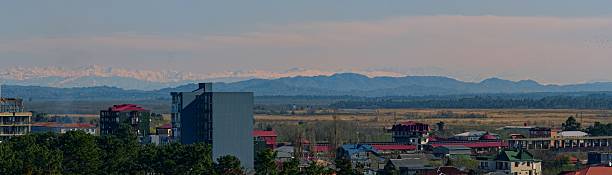 istock Sunny Town View with Misty SnowCapped Mountains Background 2250005707