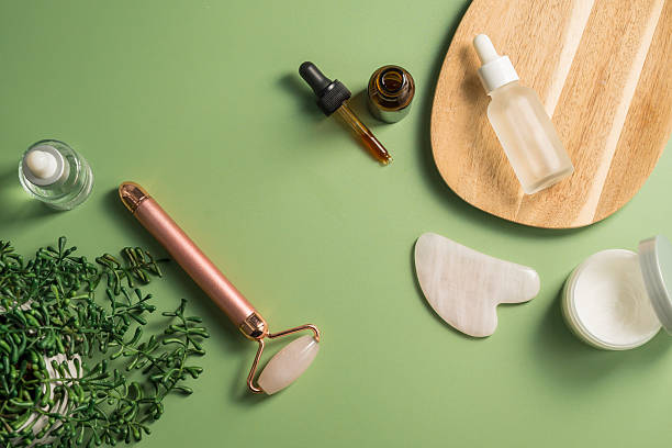 istock Rose quartz gua sha tool and face massage roller on green background, beauty abstract photo. Top view 2250006351