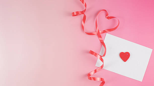 istock Pink ribbon heart and white envelope on pink background with copy space 2250006428