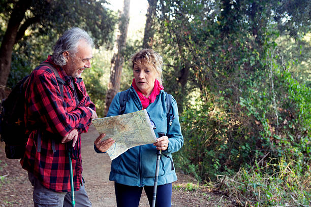 istock Senior couple hiking trail reviewing map for direction 2250006997