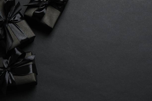 istock Black boxes decorated with a satin ribbon on a dark background 2250008081