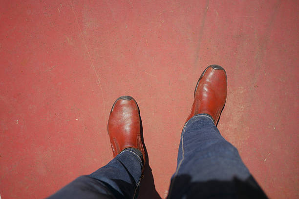 istock Brown leather boots on red background at outdoor location 2250008090