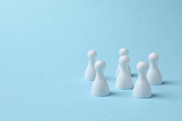 istock Group of colored pawns on a blue table. Concept of unity 2250008182