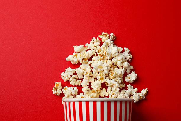 istock Delicious popcorn in a striped cardboard basket on a colored background 2250008274