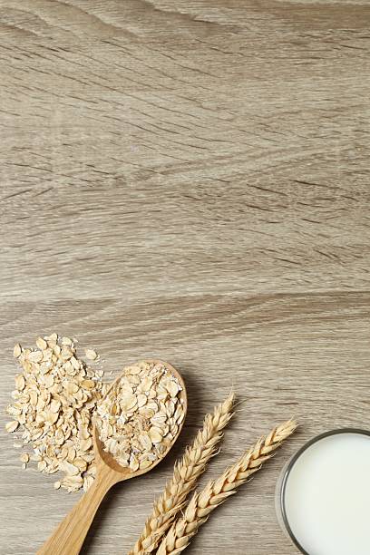 Composition with oatmeal flakes on wooden background. Cooking breakfast