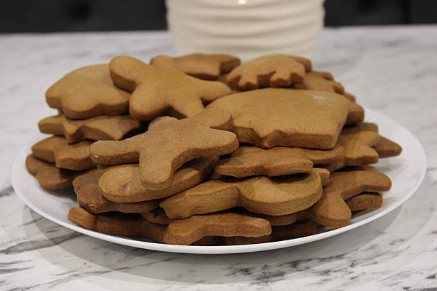 istock Gingerbread cookies sit on a white plate on a marble countertop after being cut into various shapes for a holiday treat 2250015478