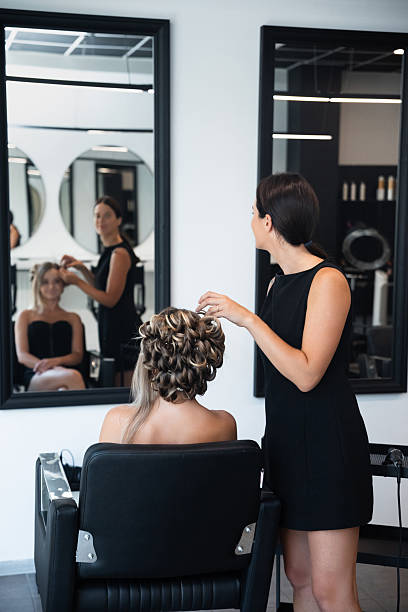 istock Elegant hairstyle creation in modern salon during daytime with client admiring her reflection in large mirrors 2250018258