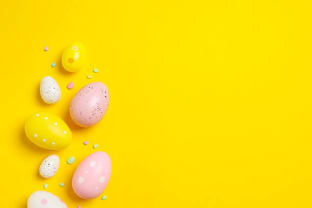 istock Happy Easter. Colorful eggs on yellow background, space for text or advertising 2250018883