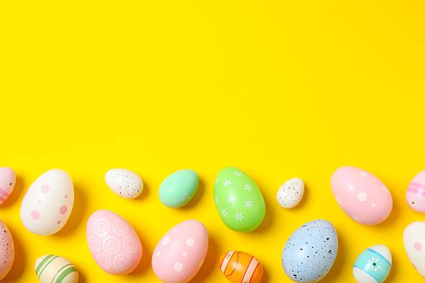istock Happy Easter. Colorful eggs on yellow background, space for text or advertising 2250018943