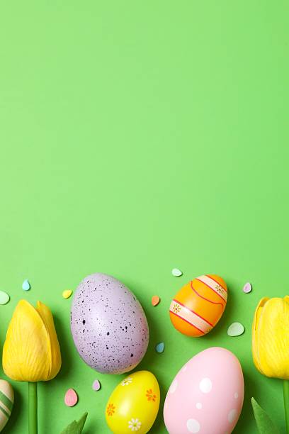 istock Happy Easter. Colorful eggs with tulips on green background, space for text or advertising 2250019025