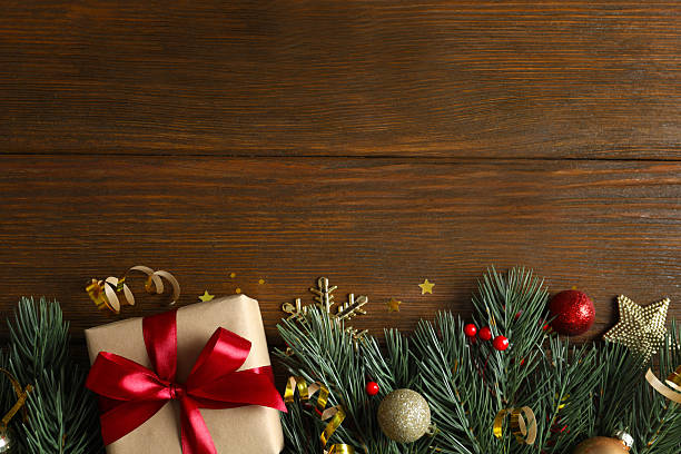 istock Beautiful gift box tied with bow and decorations on wooden background 2250019909