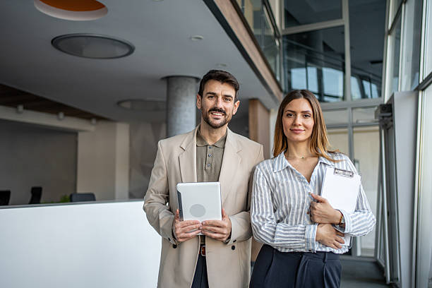 istock Business colleagues standing in modern office holding digital tablet 2250025400