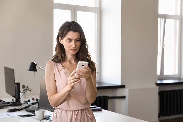 istock Focused serious young office worker woman using online app 2250025721