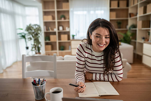 istock Happy woman working home office writing notes 2250029683