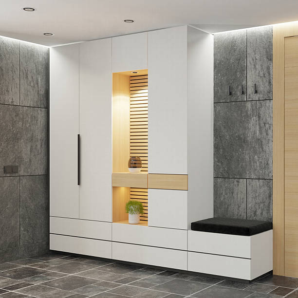 Modern building entrance hallway design featuring dark stone tile flooring and a mix of smooth white and textured gray walls. Light wood door with vertical frosted glass panel is centered, flanked by a tall window and potted plant. Built-in white cabinet with warm lighting and mirror adds depth. Abstract wall art and recessed ceiling lights complete the clean, modern look. Ideal for interior design, architecture, lifestyle, and residential themes.