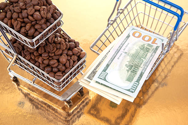 istock A tiny cart filled with coffee beans sits next to $100 bills on a golden table, representing the intersection of agriculture and wealth. 2250035851