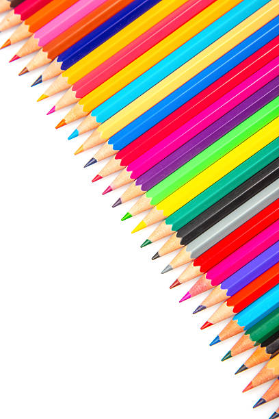 A spectrum of sharpened colored pencils arranged in a straight line on a white background. Great for illustrating creativity, school supplies, or art-related themes.