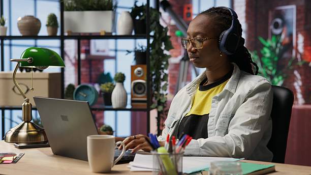 istock Woman enjoying music while researching data for company project on laptop 2250039061