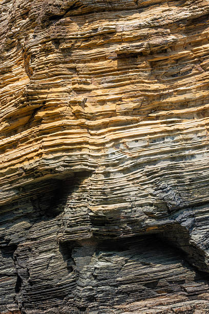 layered coastal rock formations showing rich textures, colors, and erosion patterns, highlighting geological strata shaped by natural forces over time