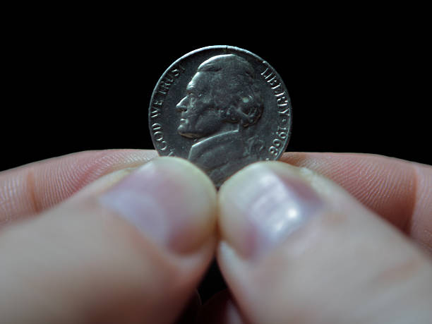 istock American Nickel Coin Held Between Fingers 2250041090