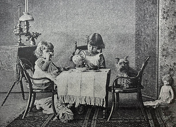 istock Antique illustration - two small girls sitting at a small table having a tea party with their dog 2250042866