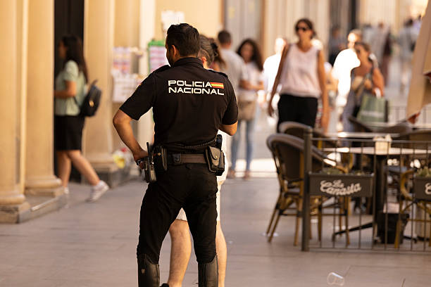 Seville, Andalusia, Spain - July 16, 2025: A National Police Corps officer responds to the scene of an emergency.