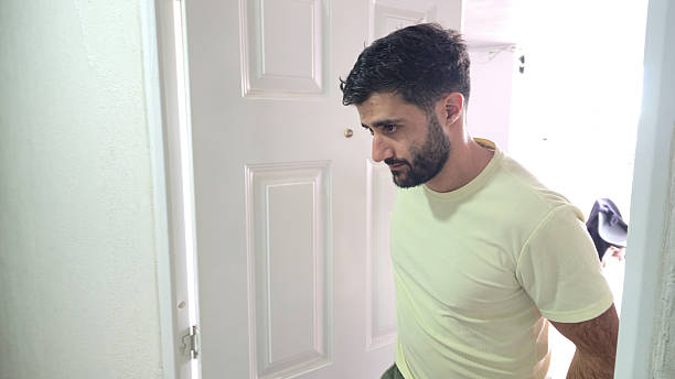 istock Bearded man walking through white doorway at home 2250046176