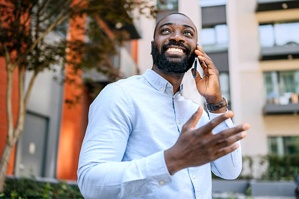 istock Businessman talking on the phone while standing outdoors in a city setting during daylight 2250050288