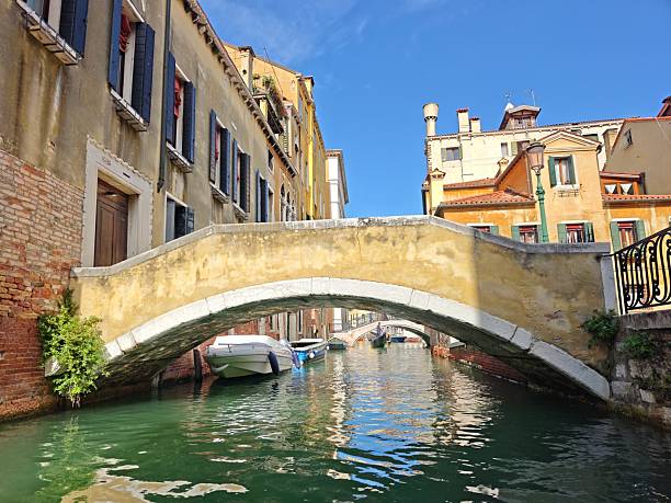 Venice,Italy-Sep.28th 2025: Stone bridge over a small canal in Venice with buildings