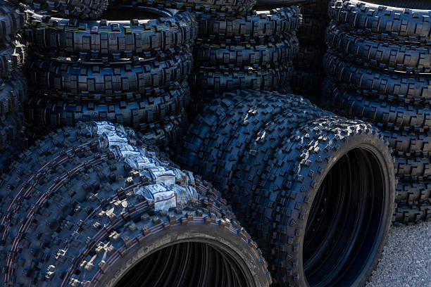 A pile of off-road and enduro motorcycle tires arranged in stacks with visible labels and packaging.