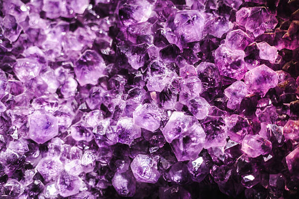 Vibrant amethyst crystal cluster with deep purple facets and sparkling geometric formations. High quality photo