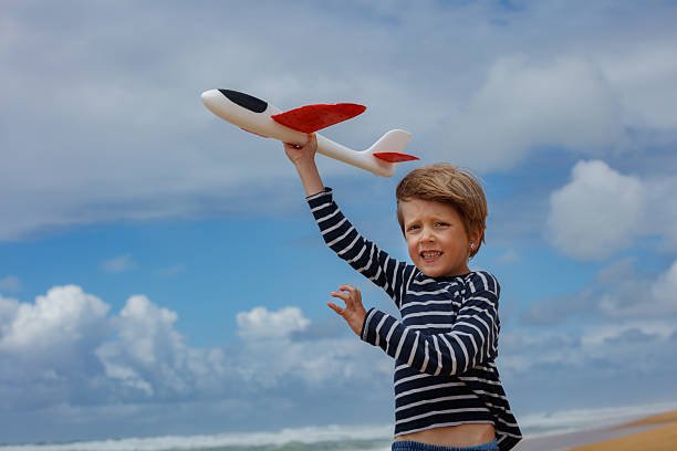 istock Happy kid hold toy airplane over head outdoors ready to launch 2250058706