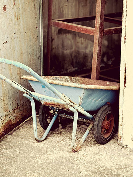 istock Old blue wheelbarrow in front of an old abandoned building. 2250059100