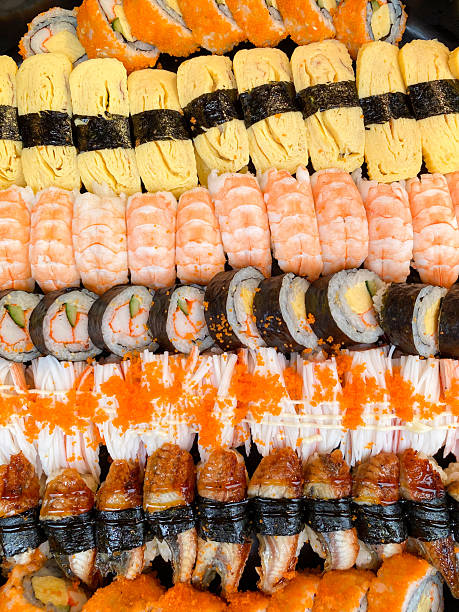 Assorted sushi platter featuring tamago rolls, crab stick rolls, tamago, unagi, ebi, and kani, beautifully arranged on a serving tray for catering events.