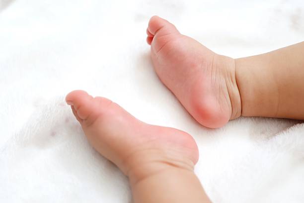 The soft bare feet of a baby and a soothing baby photo image.