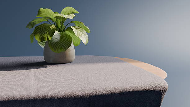 An indoor plant with green leaves is placed in a gray pot on a modern furniture surface with a neutral background, creating a calm and aesthetic interior scene