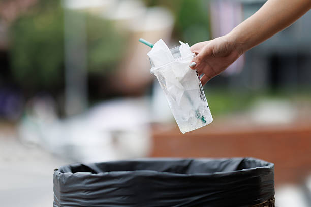 istock Woman throwing plastic cup in a trash bin on a blurred background 2250062114