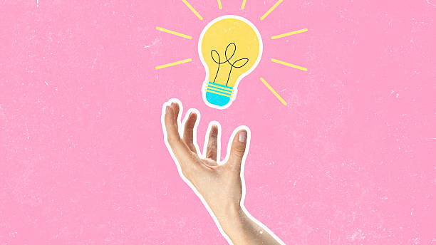 istock Creative hand reaching for a light bulb against a pink background 2250063947