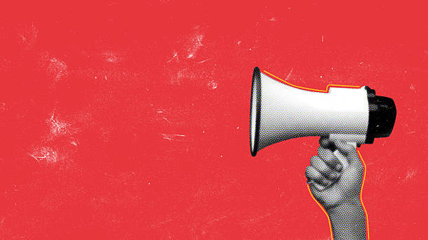 istock Hand holding megaphone in front of bright red background during a protest rally 2250065528