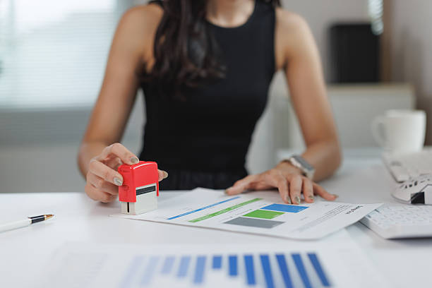 istock Businesswoman stamping official document in office 2250065598