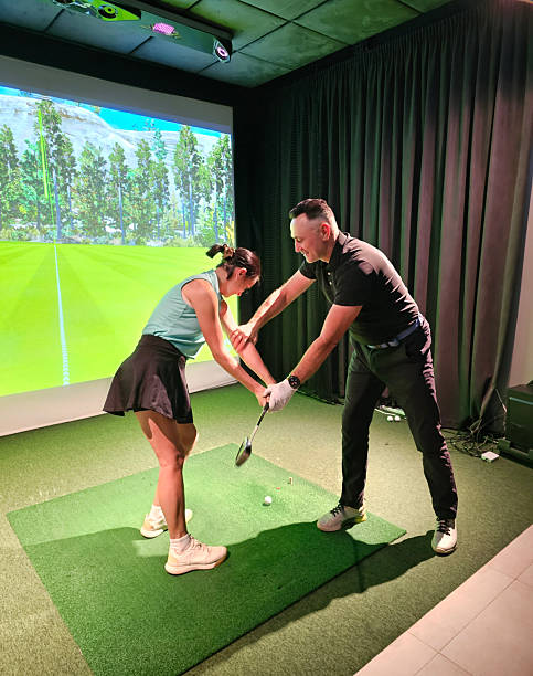 istock Golf lessons take place indoors with a coach guiding a student in a practice session concept 2250068267
