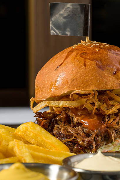 Slow-cooked beef brisket burger served with fries and sauces