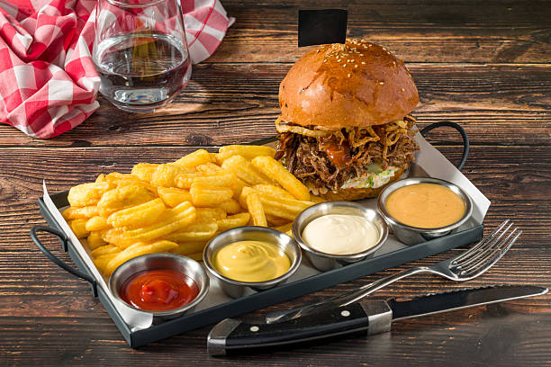 Slow-cooked beef brisket burger served with fries and sauces