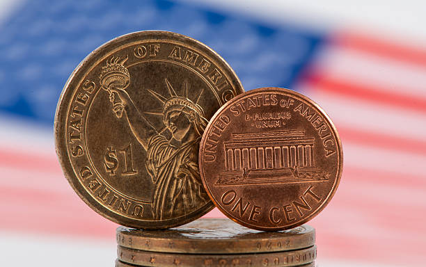 istock US $1 coin, 1 American cent coin and US flag  on a white background 2250071605