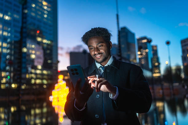 istock Young black man using smartphone at night in city 2250078178