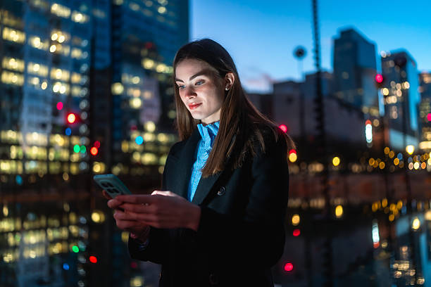 istock Woman using smartphone outdoors at night in city 2250078204