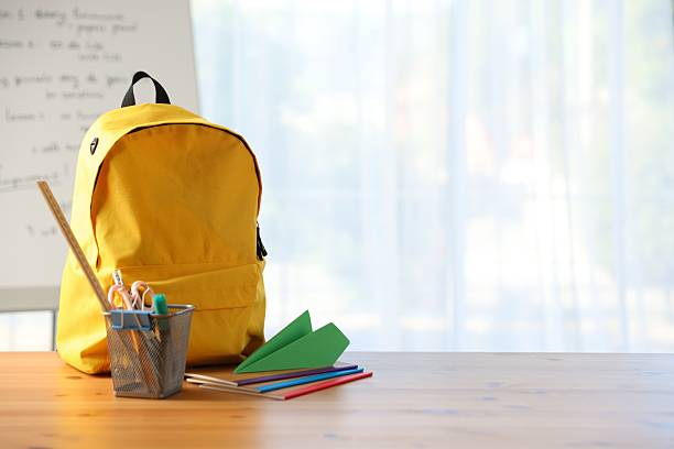 istock Backpack, different stationery and paper plane on desk in classroom. Space for text 2250080184