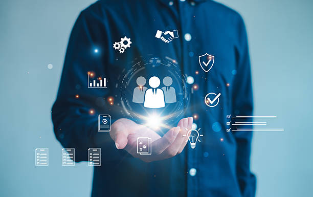istock person presenting a glowing digital team icon surrounded by business, analytics, checklist, and security symbols. Ideal for HR management, recruitment, teamwork, and corporate workflow concepts. 2250080400